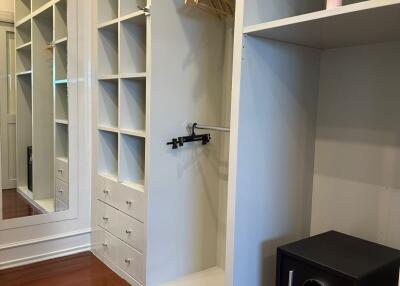 Spacious walk-in closet with shelving and a safe