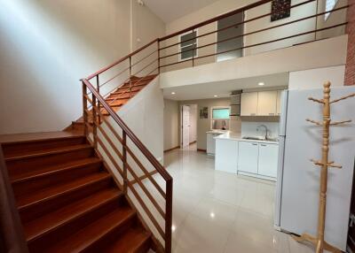 Modern open-concept kitchen and living area with staircase