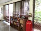 Spacious living room with large windows and wooden blinds