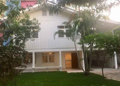 Front view of a white two-story house with garden