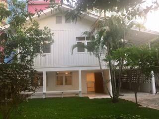 Front view of a white two-story house with garden