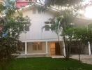 Front view of a white two-story house with garden