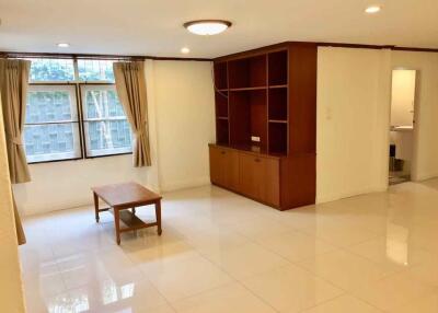 Spacious living room with built-in shelving and natural light