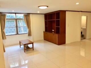 Spacious living room with built-in shelving and natural light