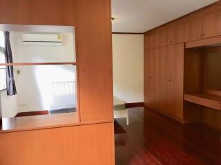 Spacious bedroom with wooden wardrobes and air conditioning