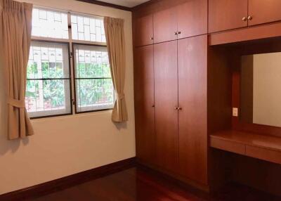 Bedroom with large built-in wooden wardrobe and vanity mirror