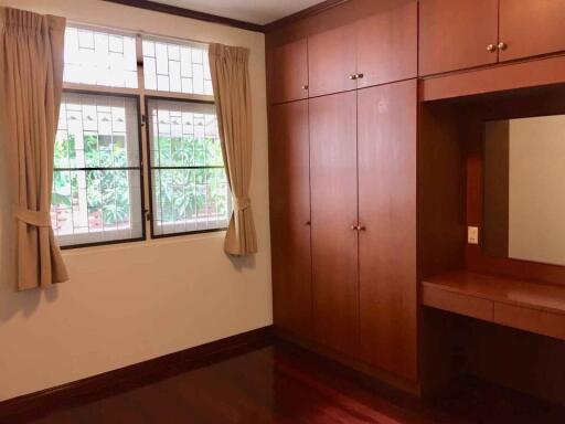 Bedroom with large built-in wooden wardrobe and vanity mirror