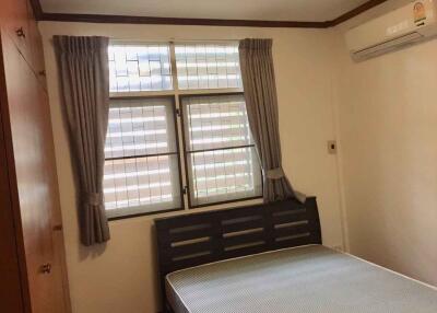 Bedroom with window, air conditioner, and bed frame