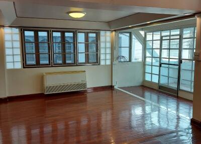 Spacious living room with wooden flooring and large windows