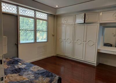 Spacious bedroom with large windows and built-in cabinets