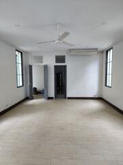 Spacious living room with ceiling fan and large windows