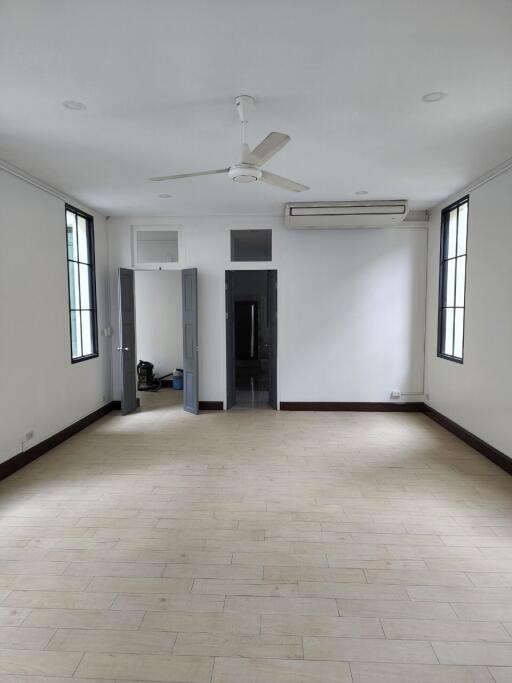 Spacious living room with ceiling fan and large windows