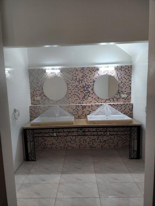 Modern bathroom with twin sinks and mosaic wall tiles