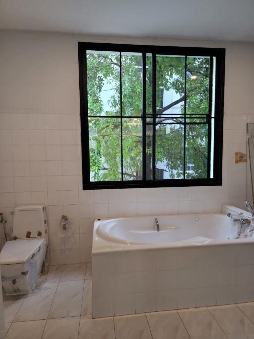 Bathroom with window, bathtub, and toilet