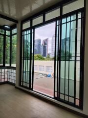 Bright and modern enclosed living area with large windows offering a city view.