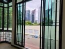 Bright and modern enclosed living area with large windows offering a city view.