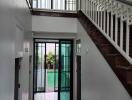 Stairway and hallway with a view to a glass door and pool area