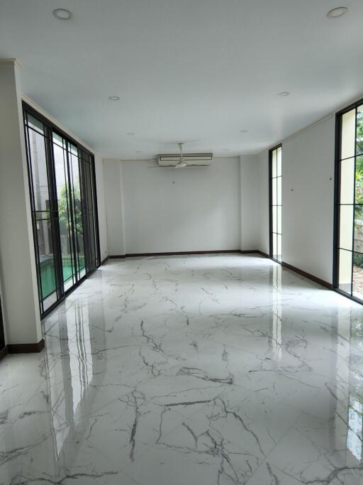 Spacious living room with marble flooring and large windows