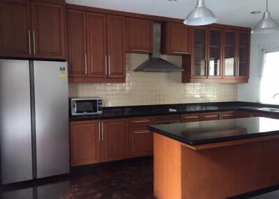 Modern kitchen with wooden cabinets, stainless steel appliances, and a center island