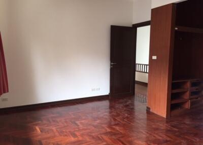 Spacious bedroom with wooden flooring and built-in storage space