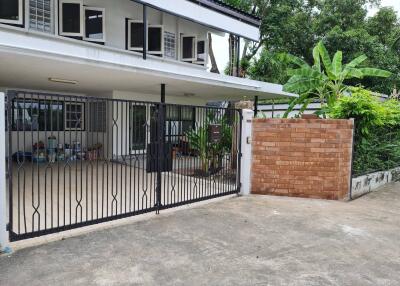 Front view of the house with a gate and garden