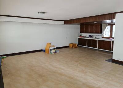 spacious kitchen with tiled floor and wooden cabinets