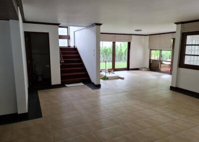 Spacious living room with large windows and staircase