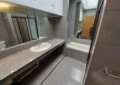 Modern bathroom with a sink, bathtub, and large countertop