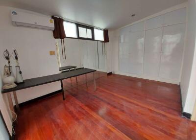 Spacious bedroom with wooden flooring and built-in wardrobes