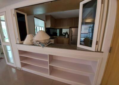 Modern kitchen with open shelving and view into living area