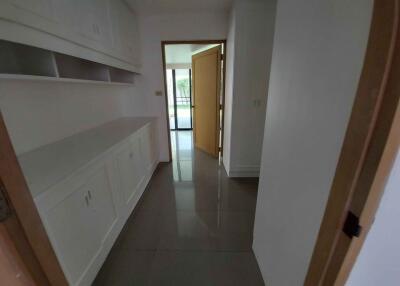 Hallway with built-in cabinets and view of the main area