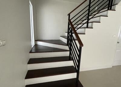 Modern staircase with wooden steps and metal railing