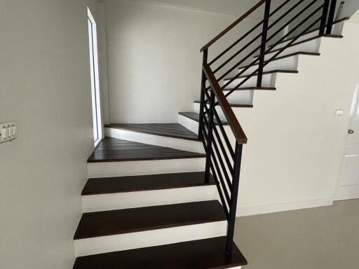 Modern staircase with wooden steps and metal railing