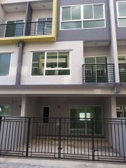 Modern multi-story residential building with balconies and gated entrance