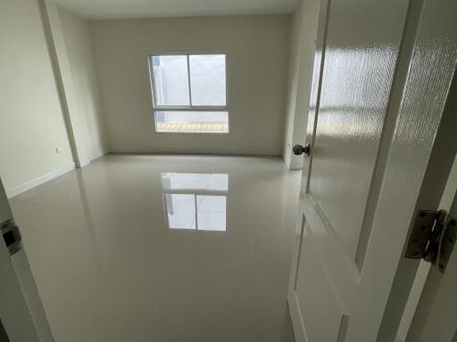 Empty bedroom with white walls and a window