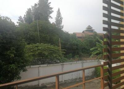 view of trees and building from balcony