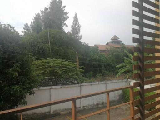 view of trees and building from balcony