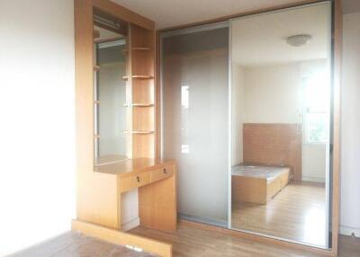 Bright bedroom with large mirrored closet and wooden furniture