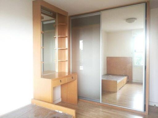 Bright bedroom with large mirrored closet and wooden furniture