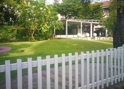 Front yard garden with white picket fence and greenery