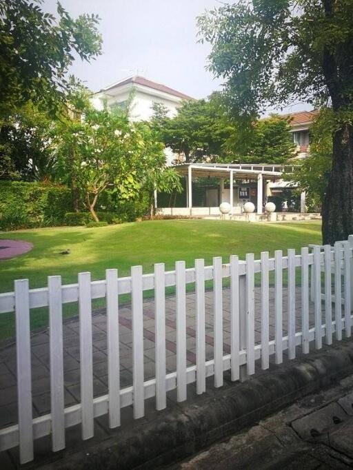 Front yard garden with white picket fence and greenery