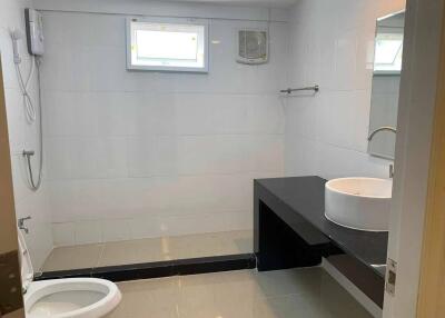 Modern bathroom with a vanity, showerhead, and toilet