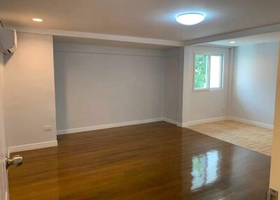 Spacious living room with a mix of hardwood and vinyl flooring