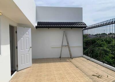 Outdoor terrace with tiled floor and a ladder against the wall