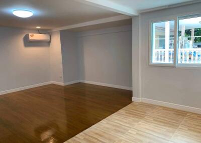 Spacious living room with wooden flooring and large window