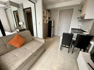 Modern studio apartment with sofa, table, and kitchenette