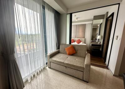 Modern bedroom with a sofa and balcony view