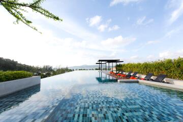 Infinity pool with lounge chairs and scenic view