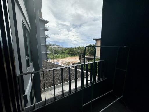 View from balcony with distant buildings and cloudy sky