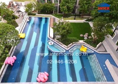 Swimming pool with surrounding greenery and buildings